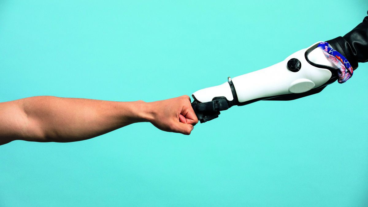 Ein Menschenarm und ein Roboterarm geben sich einen Fistbump.