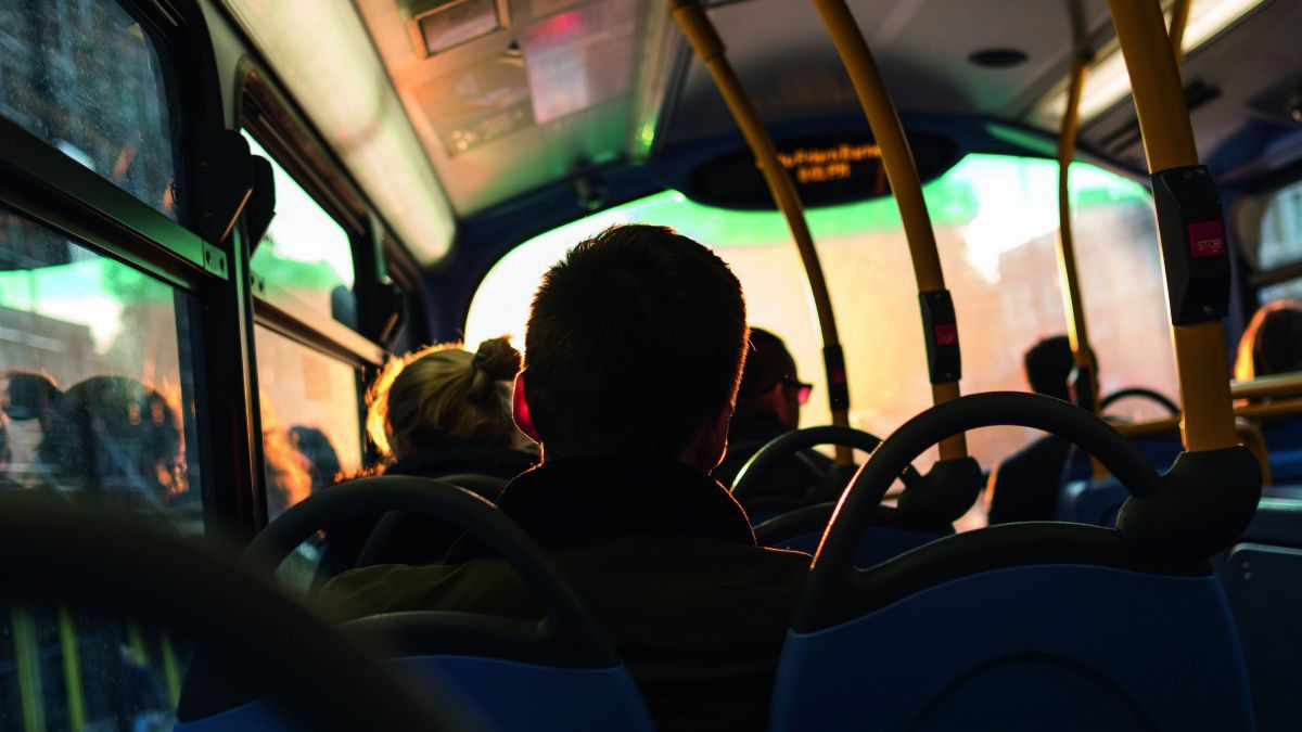 Sitzreihen und Köpfe sind in einem Bus gegen die Sonne fotografiert.