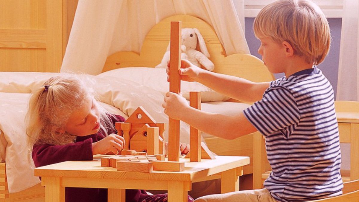 Zwei Kinder spielen mit Bausteinen an einem Tisch. Zwei Kinder spielen mit Bausteinen an einem Tisch.