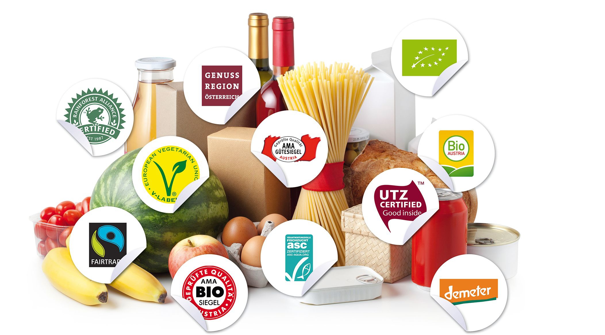 Unterschiedliche Lebensmittel wie Nudeln, Äpfel, Eier, Wein, Bananen liegen auf einem weißen Hintergrund. Darüber kleben unterschiedliche Gütesiegel-Sticker.
