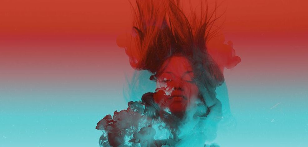 Ein künstlerisches Bild mit einem Farbverlauf von türkis bis rot in dem einerseits aufsteigende Farbwolken sowie das Gesicht einer Frau zu sehen sind