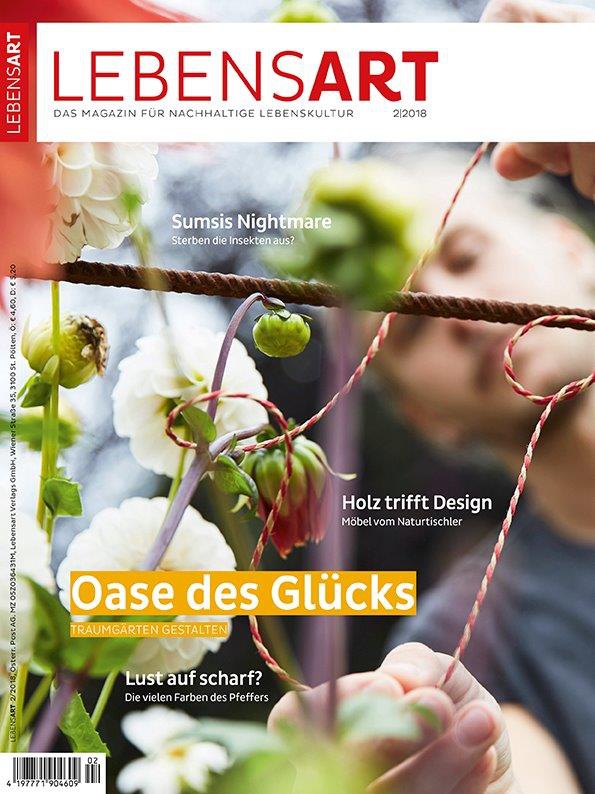 Ein Mann bindet blühende Sträucher an ein Pflanzenklettergerüst.