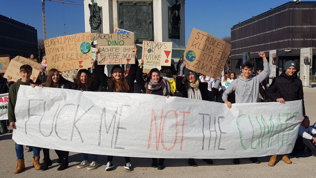 Junge Menschen halten ein Transparent in der Hand auf dem steht: Fuck me not the climate.
