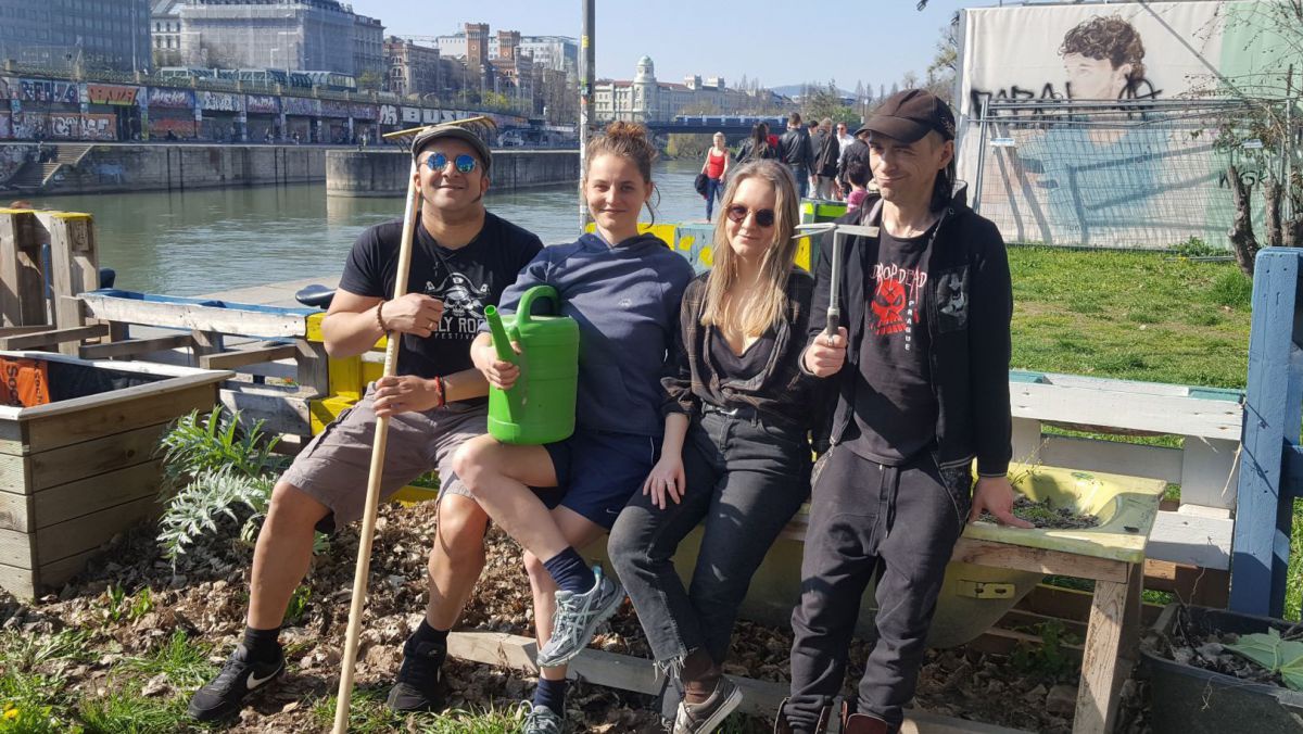 Vier junge Menschen mit Gartengeräten am Donaukanal.