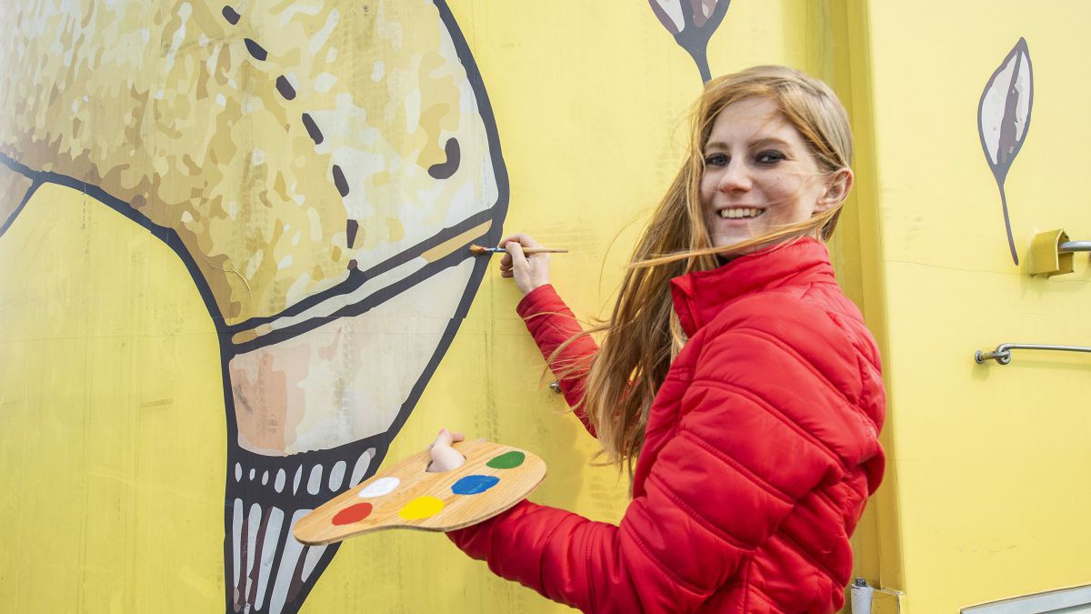 Frau gestaltet ein Windrad künstlerisch.