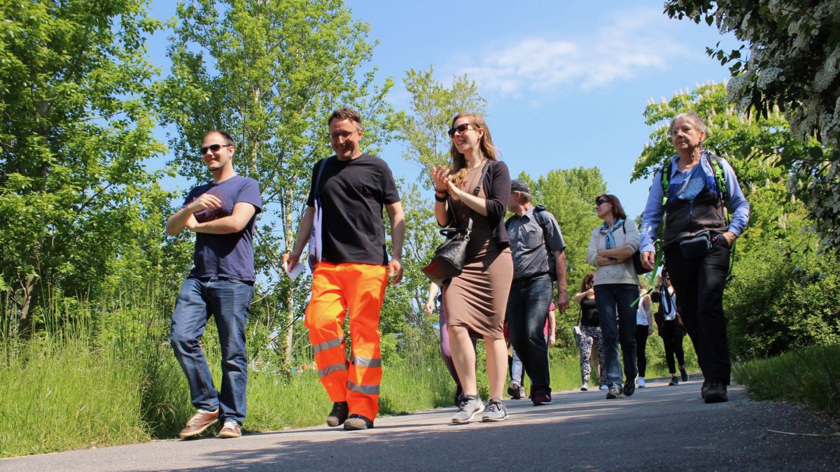 Menschen spazieren gemeinsam durch den Park.