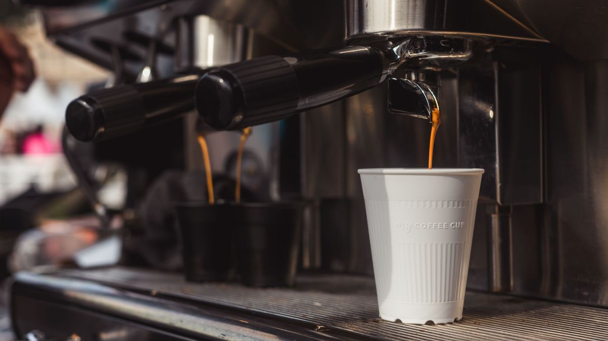 weißer Becher unter der Kaffeemaschine