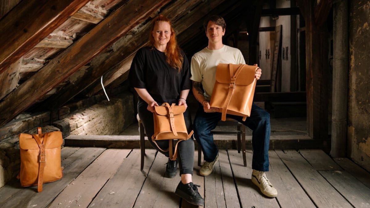 Nadine und Lukas halten Ledertaschen.