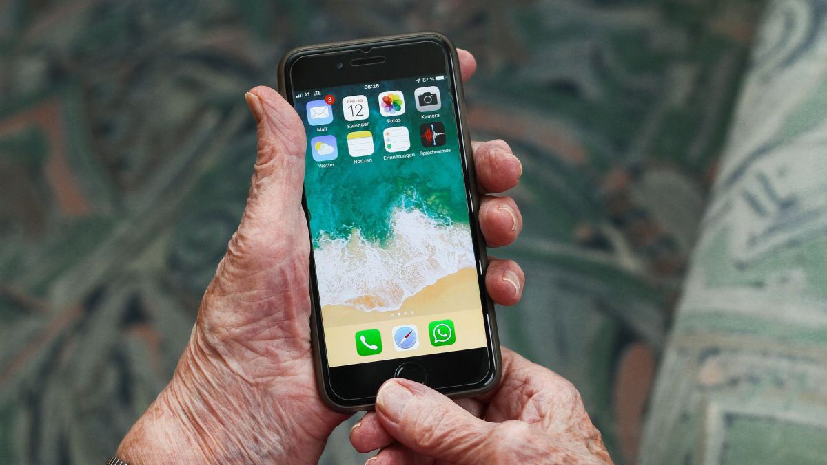 Alter Mann hält Handy