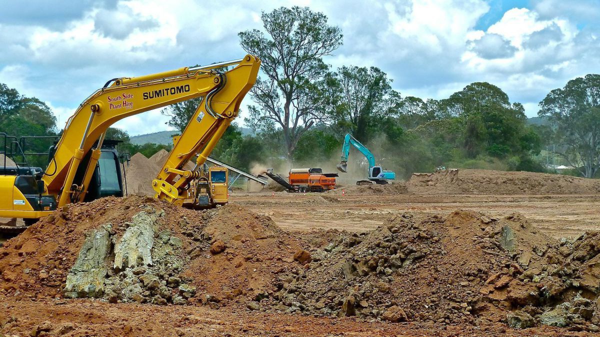 Bagger schieben Ackererde weg.