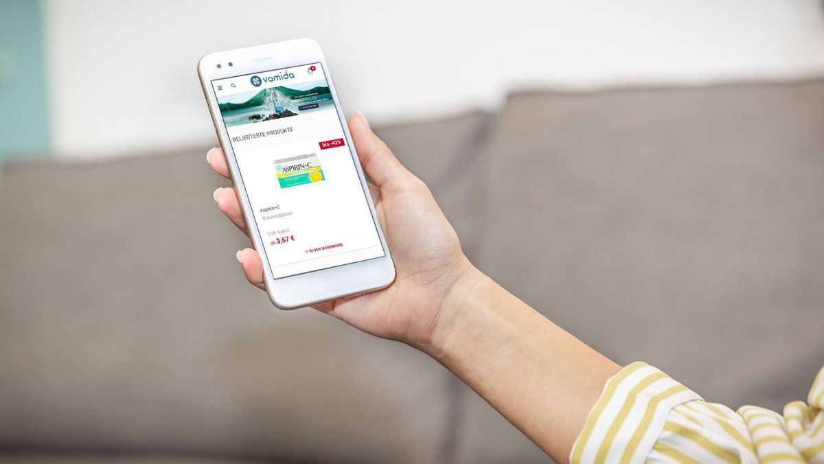 Frau hält Mobiltelefon zur Onlinebestellung.