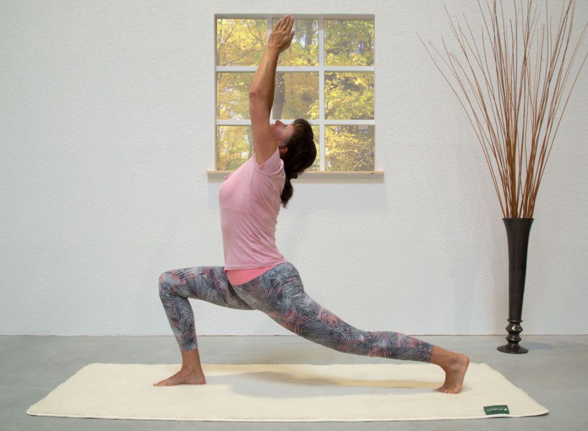 Frau in Yogahaltung auf der Yogamatte 