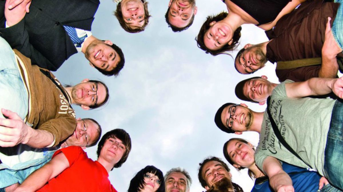 Junge Menschen stehen im Kreis und schauen in die Kamera nach unten. Foto: Allzweck-Jack-Photocase