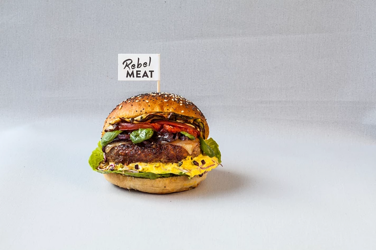 Ein schmackhaft aussehender Burger mit Rebel Meat Flagge.