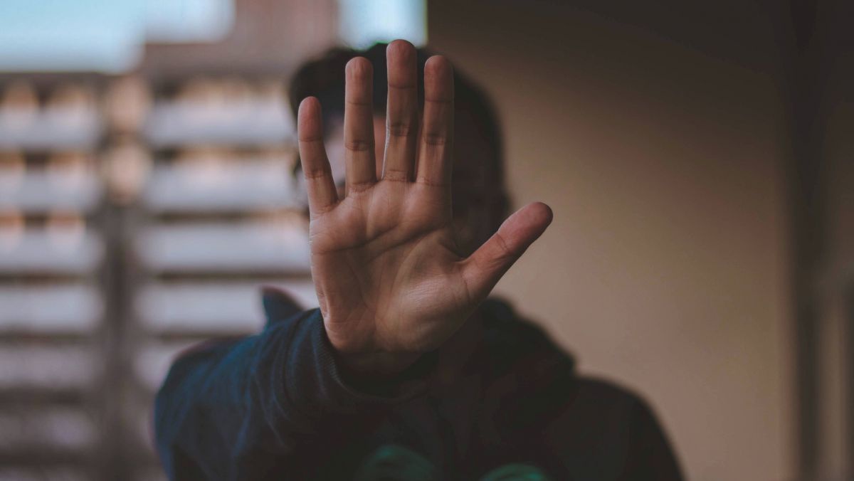 Eine Person hat die Hand ausgestreckt, die Handfläche zeigt zur Kamera.