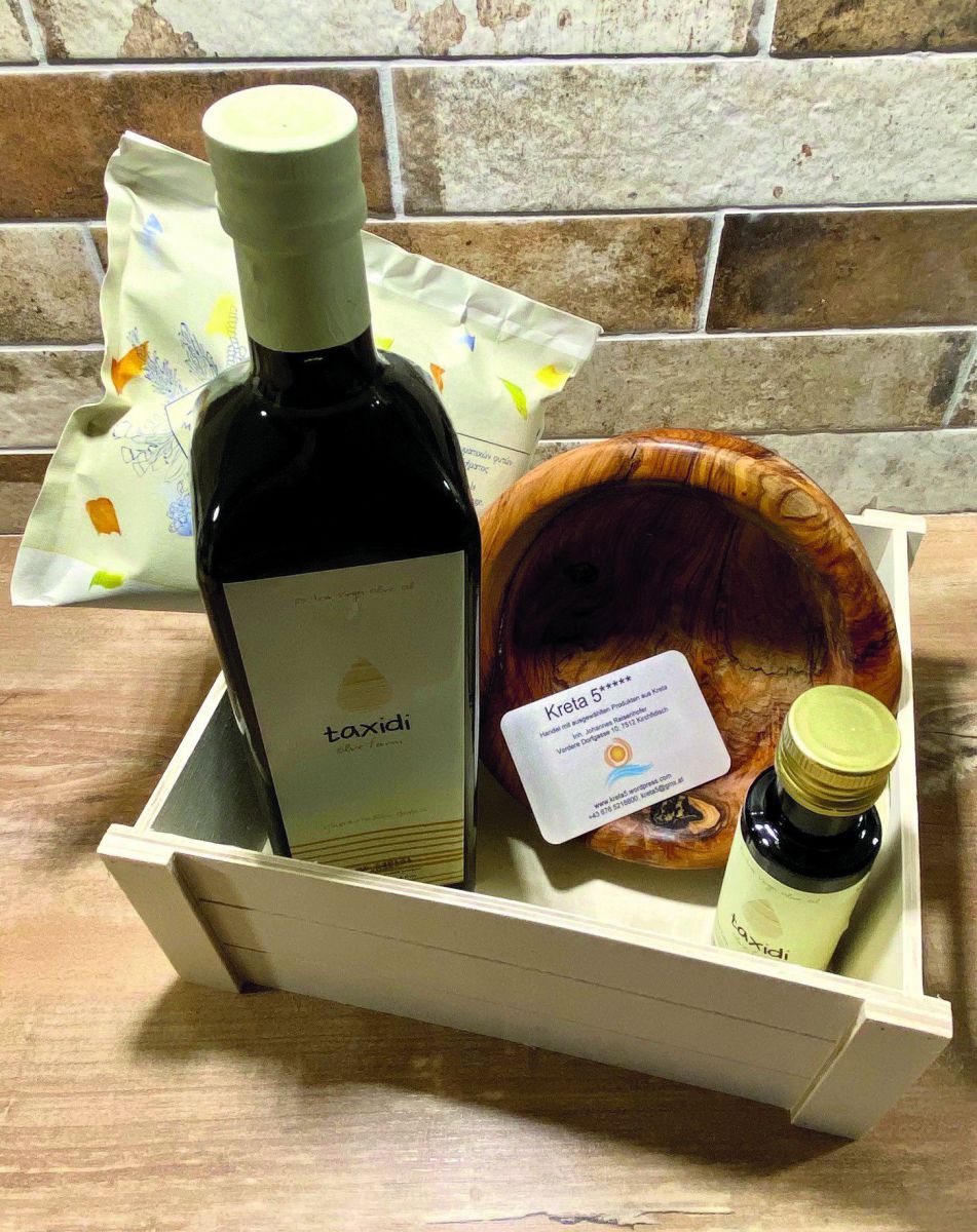 Eine Geschenkkiste mit Olivenöl und einer Olivenholzschale.