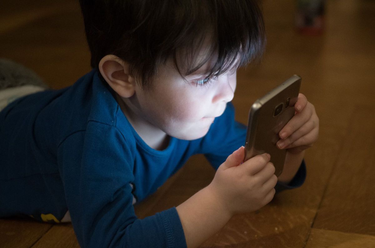 Ein Kleinkind starrt wie gebannt auf einen Handybildschirm.