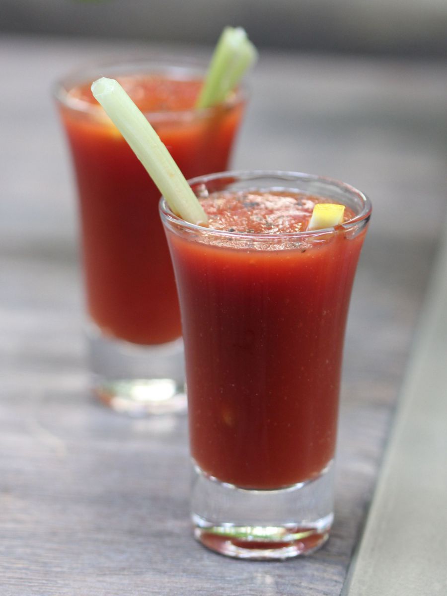 Zwei Gläser Tomatensaft mit Sellerie ganiert.