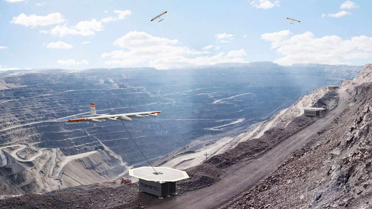 Über dem Krater eines monströsten Steinbruchs schweben Drohnen zur Stromgewinnung, sie sehen Modellflugzeugen ähnlich und sind durch eine Leine mit einem Generator auf dem Boden verbunden.