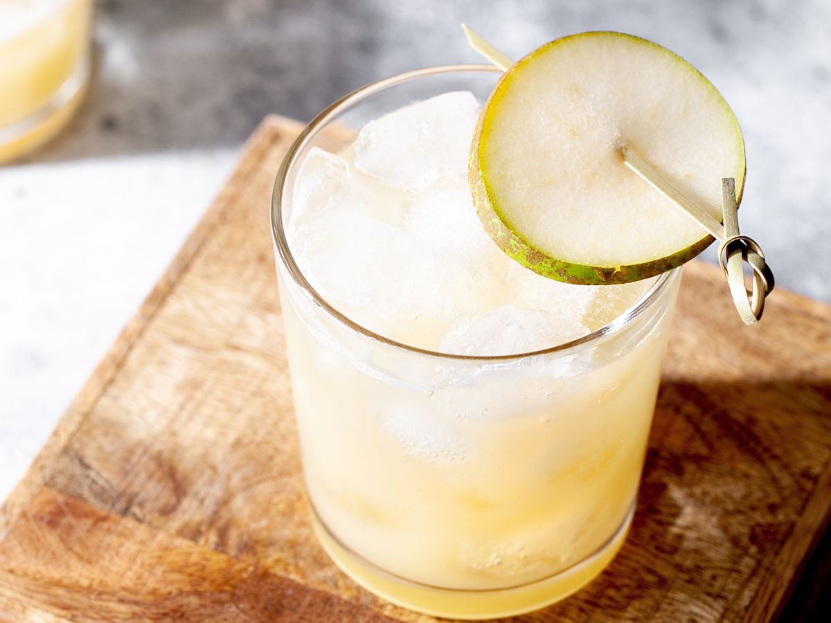 Cocktails in Gläsern, garniert mit einer dünnen Obstscheibe.