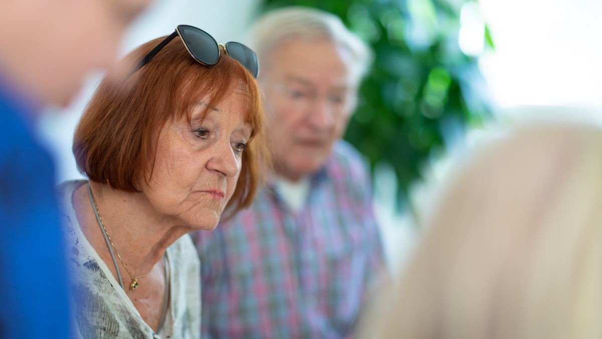 Vier Senior*innen sitzen zusammen im Gespräch.