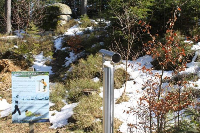 Ein Fernrohr mit einer Handlungsanleitung steht in einer winterlichen Landschaft.