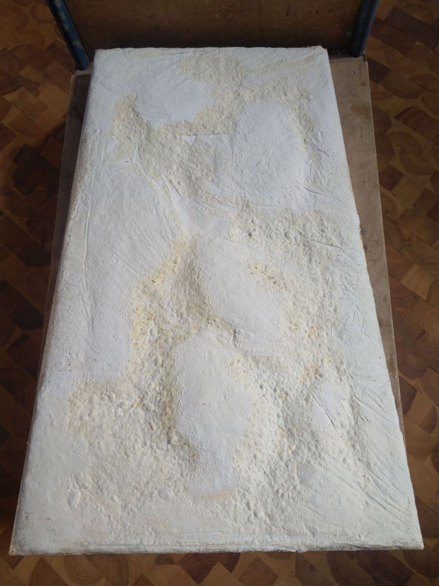 Eine steinern anmutende weiß-gelbliche Platte.