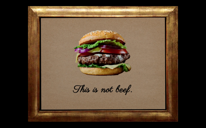 In einem goldenen Rahmen ist das Bild eines Burgers. Unter dem Burger steht 