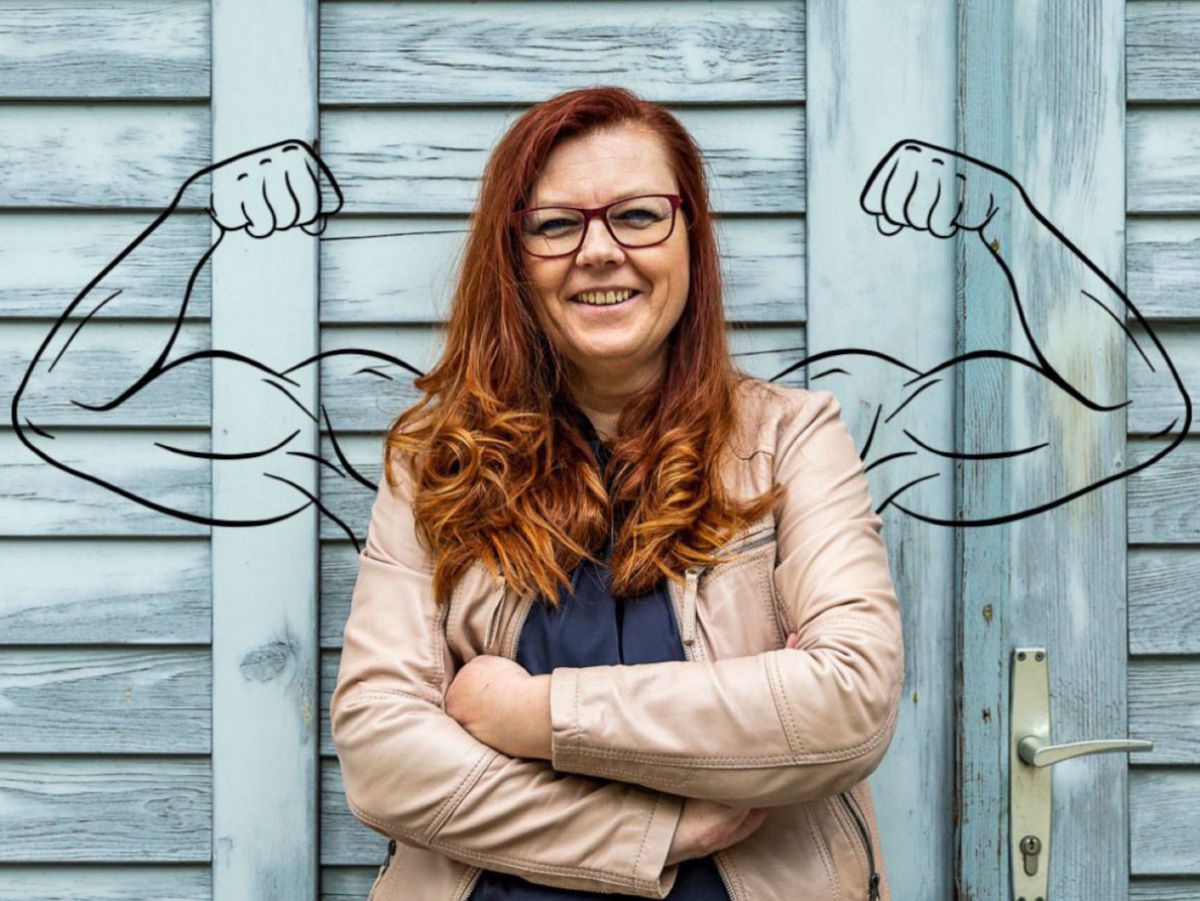 Foto der Autorin Ingeborg Kuca. Sie steht mit verschränkten Armen lächelnd vor einem Holztor, im Hintergrund sind muskulöse Arme in der Haltung eines Bodybuilders skizziert.