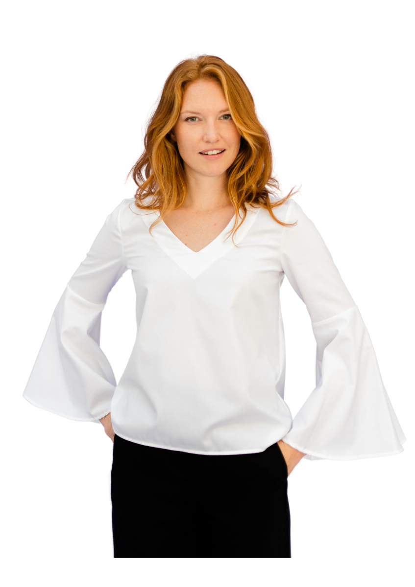 Ein weibliches Model mit langem rotblonden Haar posiert in schwarzer Hose und weißem Oberteil mit V-Neck und weiten Glockenärmeln.