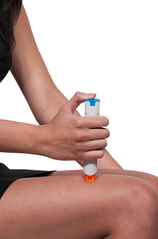 Ein EpiPen wird gegen den Oberschenkel einer Frau gedrückt.