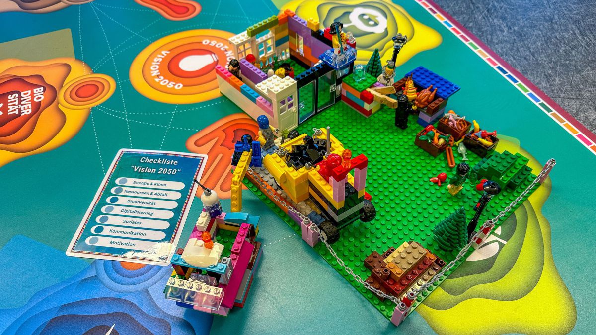 Auf einer Matte ist ein Lego-Brett aufgestellt auf dem Teile einer Baustelle nachgebaut wurden.