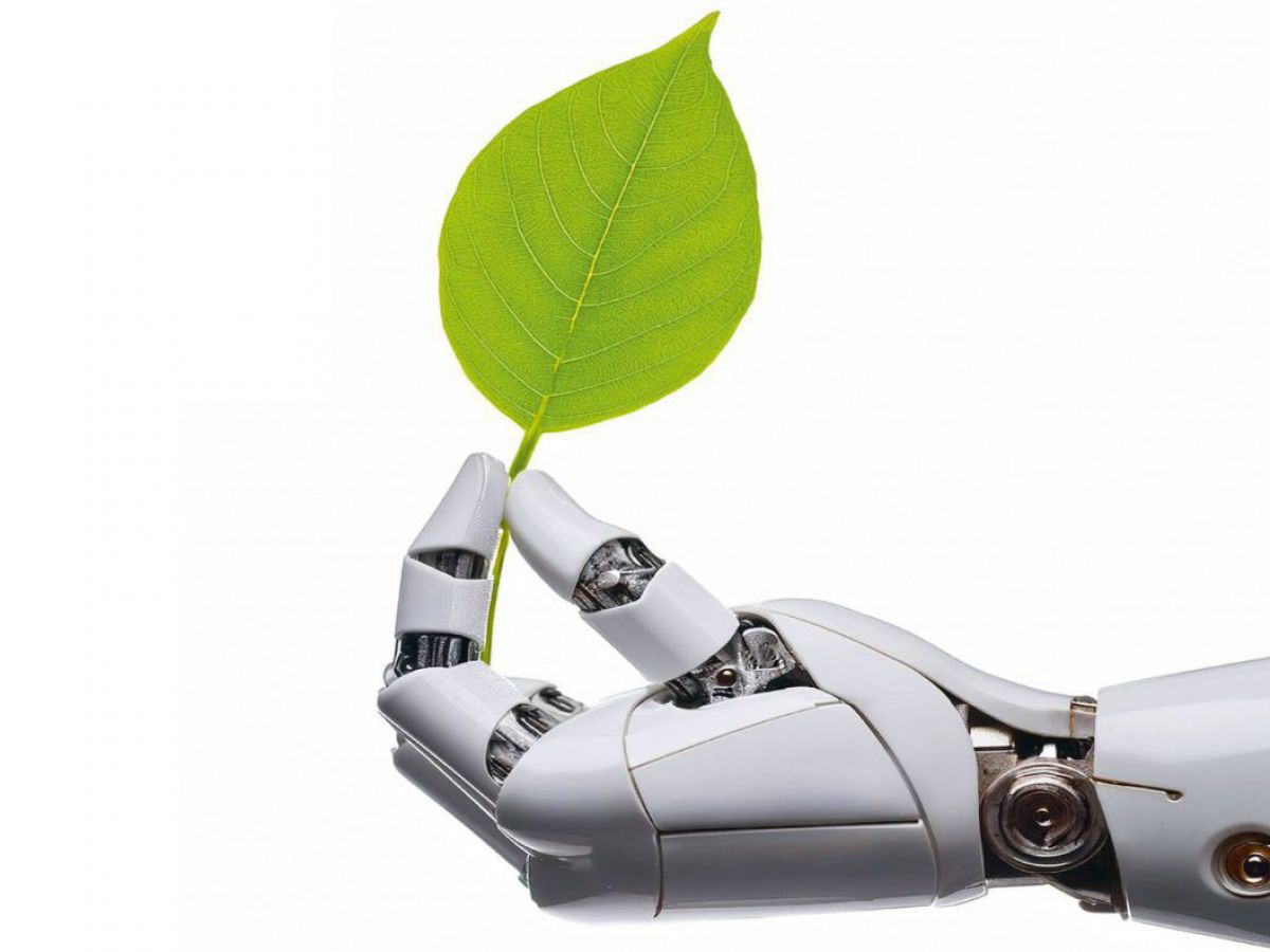Eine humanoide Roboterhand hält ein grünes Blatt an seinem Stiel zwischen Daumen und Zeigefinger.