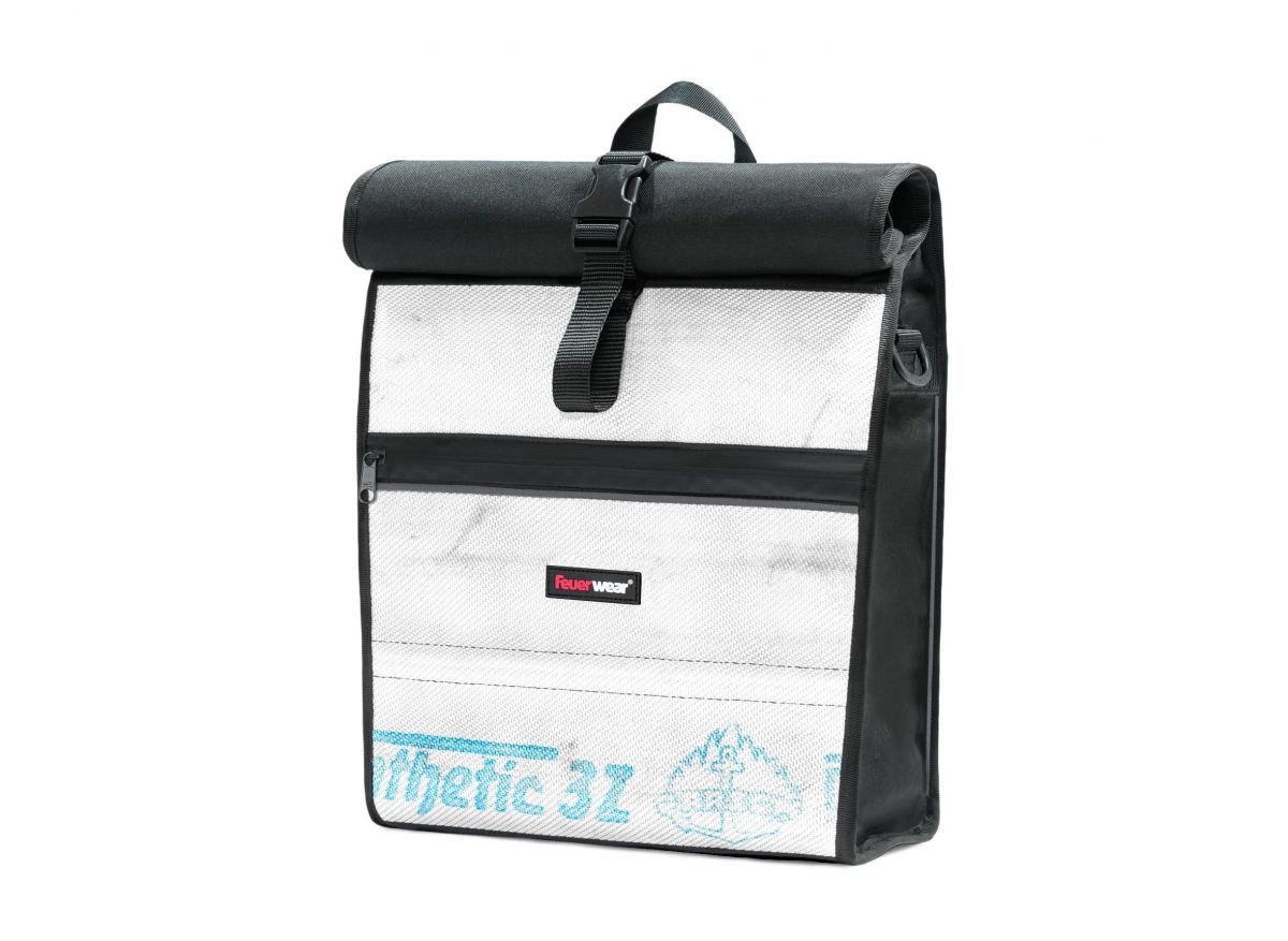 Eine Rolltop-Tasche aus weißem Feuerwehrschlauch mit Gebrauchsspuren und schwarzer Plane.