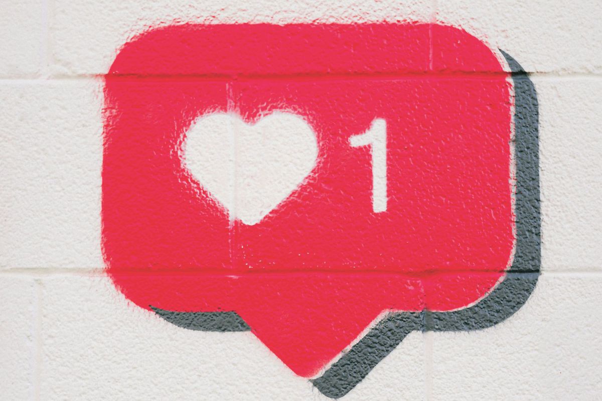 Graffiti auf einer weiß getünchten Mauer: Eine rote Sprechblase mit schwarzem Schatten, im digitalen Stil, darin ein weißes Herz und eine 1 daneben.