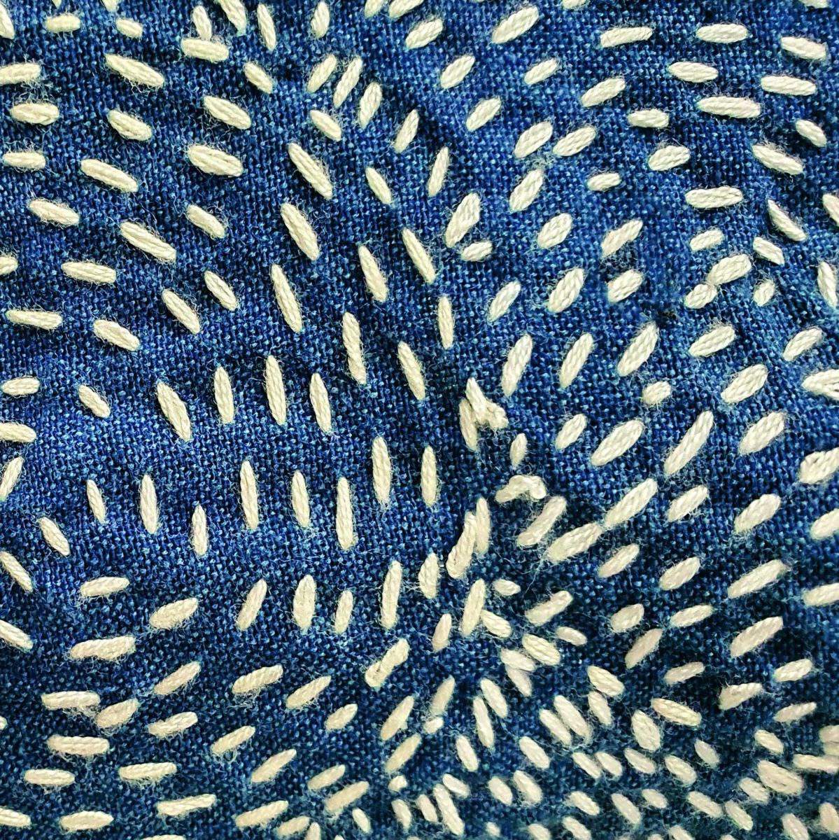 Ein mit kreisförmigen Mustern besticktes Stück Stoff.