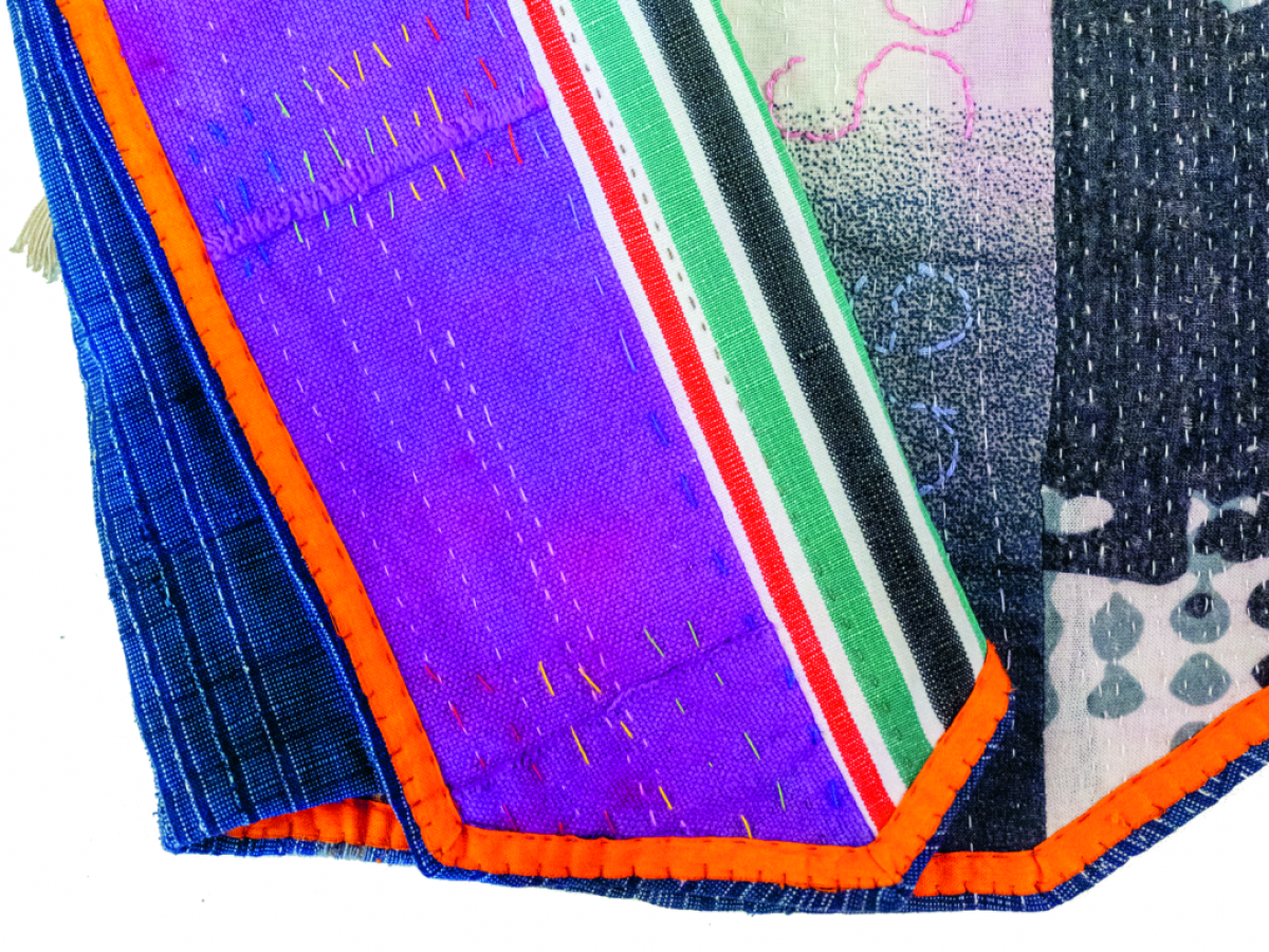 Ein buntes Textilkunstwerk aus Patchwork und Stickereien.